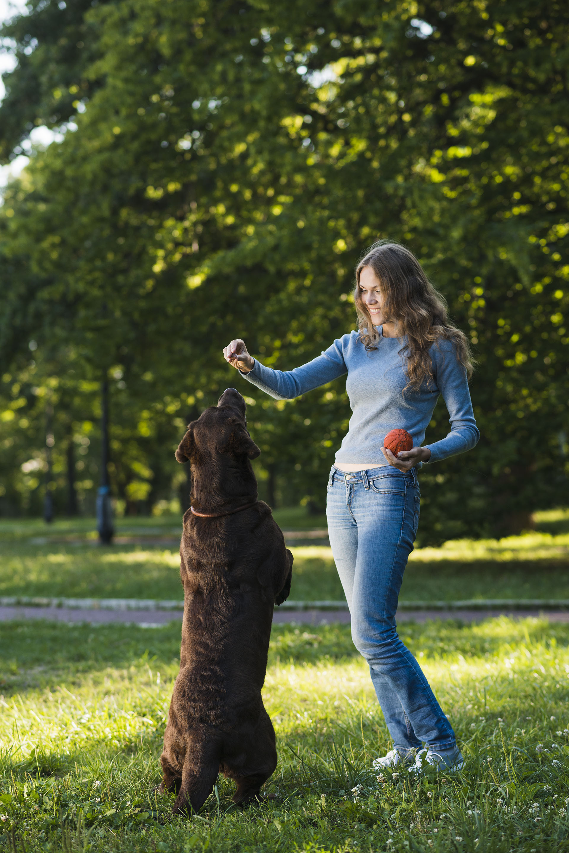 mujer-joven-divirtiendose-su-perro-jardin